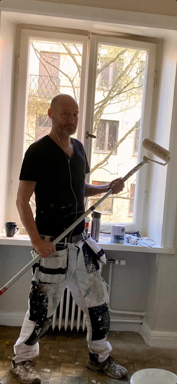 Kristoffer Svartholm målar vägg med roller